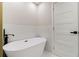 Bathroom featuring freestanding soaking tub and tiled walls at 1189 Gardenia Nw St, Atlanta, GA 30314