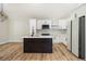 Modern kitchen with white cabinets, backsplash, black island, stainless steel appliances, and wood floors at 1189 Gardenia Nw St, Atlanta, GA 30314
