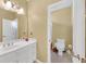 Bright bathroom with white vanity, dual sinks, mirror, toilet and tiled floors at 20 Balfour Dr, Covington, GA 30014