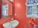 Powder room featuring a pedestal sink, decorative mirror, and natural light at 20 Balfour Dr, Covington, GA 30014