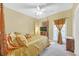 Bedroom featuring a four-poster bed with gold bedding, a TV, and a window with curtains at 20 Balfour Dr, Covington, GA 30014