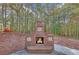 Cozy outdoor brick fireplace feature with decorative accents in a wooded backyard setting at 20 Balfour Dr, Covington, GA 30014