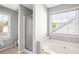 Well-lit bathroom showcasing a glass enclosed shower and soaking tub with natural light at 4606 Liberty Square Dr, Acworth, GA 30101