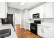 Modern kitchen with white cabinets, stainless steel microwave, and hardwood flooring at 4606 Liberty Square Dr, Acworth, GA 30101