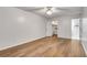 Open bedroom with hardwood floors, ceiling fan, neutral paint, and en suite access to a bathroom at 6851 Roswell Rd # A21, Sandy Springs, GA 30328