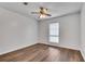 A clean bedroom with a ceiling fan, hardwood floors, and a bright window at 6851 Roswell Rd # A21, Sandy Springs, GA 30328