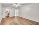 Open bedroom featuring a ceiling fan, hardwood floors, laundry room access, and neutral paint at 6851 Roswell Rd # A21, Sandy Springs, GA 30328