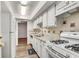 Bright white kitchen with stainless steel sink, gas range, granite counters, and white cabinets at 6851 Roswell Rd # A21, Sandy Springs, GA 30328