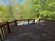 Wooden deck overlooking an in-ground pool surrounded by lush greenery and trees at 6893 Spring Valley Ct, Douglasville, GA 30135