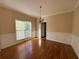 Empty dining room features hardwood floors, chandelier and large window for natural light at 6893 Spring Valley Ct, Douglasville, GA 30135