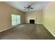 Spacious living room with a fireplace, ceiling fan, and a large window at 6893 Spring Valley Ct, Douglasville, GA 30135
