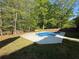 Backyard with private pool surrounded by grass and mature trees at 6893 Spring Valley Ct, Douglasville, GA 30135
