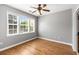 Empty bedroom with hardwood floors, three windows, and neutral-colored walls at 1261 Ashford Creek Ne Park, Brookhaven, GA 30319
