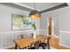 Dining room with wooden table, stylish pendant light, and wainscoting details at 1261 Ashford Creek Ne Park, Brookhaven, GA 30319