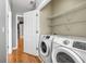 Convenient laundry room includes modern washer and dryer, plus shelving for organized storage at 1261 Ashford Creek Ne Park, Brookhaven, GA 30319