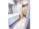 Bright bathroom with white vanity and linen closet view to toilet at 1412 Brighton Pl, Loganville, GA 30052
