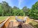 Outdoor deck featuring wooden planks with table and chair furniture set amidst lush greenery at 1412 Brighton Pl, Loganville, GA 30052