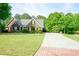 Attractive single-story brick home with an extended driveway and lush green lawn at 1412 Brighton Pl, Loganville, GA 30052