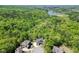 A scenic aerial view captures a home surrounded by lush greenery and a distant lake at 4208 Sierra Creek Ct, Hoschton, GA 30548