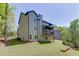 Back exterior of a home with a well-manicured lawn, a retaining wall and a view of the decks at 4208 Sierra Creek Ct, Hoschton, GA 30548