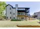 Back exterior of a multi-story home with a well-maintained lawn, showcasing multiple decks and outdoor space at 4208 Sierra Creek Ct, Hoschton, GA 30548