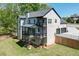 Rear view of home featuring a tiered deck, brick accents, a well-kept lawn, and tasteful landscaping at 4208 Sierra Creek Ct, Hoschton, GA 30548