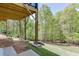 A view of the backyard beneath a raised deck, showcasing lush greenery and the natural landscape at 4208 Sierra Creek Ct, Hoschton, GA 30548
