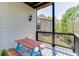 Charming balcony with a picnic table and a serene view of the backyard and neighboring brick house and lawn at 4208 Sierra Creek Ct, Hoschton, GA 30548