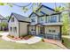 Inviting two-story home featuring a stone facade, covered porch, and lush landscaping at 4208 Sierra Creek Ct, Hoschton, GA 30548