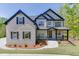 Beautiful home with a brick facade, dark shutters, gabled roof, and inviting front porch at 4208 Sierra Creek Ct, Hoschton, GA 30548