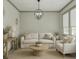 A living room features hardwood floors, a neutral color scheme, and an eye-catching, wrought-iron chandelier at 4208 Sierra Creek Ct, Hoschton, GA 30548