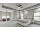 Bright main bedroom with tray ceiling, fan, sitting area, and ensuite access at 4208 Sierra Creek Ct, Hoschton, GA 30548
