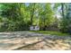 Exterior of backyard featuring small storage house and concrete drive at 5641 Roberts Dr, Dunwoody, GA 30338