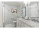 Bathroom with double vanity, marble countertop, tile flooring, and a bathtub with shower at 5641 Roberts Dr, Dunwoody, GA 30338