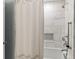Bathroom with a shower and tub combination featuring a marble tile design and shower curtain at 5641 Roberts Dr, Dunwoody, GA 30338