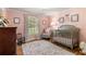 Bedroom featuring pink walls, a hardwood floor with area rug, a crib, and lots of natural light at 5641 Roberts Dr, Dunwoody, GA 30338