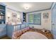 Bedroom with hardwood floors, blue paint, custom shelves, shuttered windows, and a rocking horse at 5641 Roberts Dr, Dunwoody, GA 30338