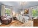 Comfortable bedroom with hardwood floors, soft lighting, and large windows at 5641 Roberts Dr, Dunwoody, GA 30338