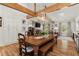 Open-concept dining area with exposed beams, hardwood floors, and a view into the living room at 5641 Roberts Dr, Dunwoody, GA 30338