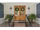 A welcoming front porch with a brick facade, wood double doors, and decorative green wreaths at 5641 Roberts Dr, Dunwoody, GA 30338