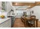 Bright kitchen and dining area with stainless steel appliances, custom cabinets, and hardwood floors at 5641 Roberts Dr, Dunwoody, GA 30338