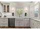 Close up of a kitchen area with white cabinets, a farmhouse sink and stainless steel appliances at 5641 Roberts Dr, Dunwoody, GA 30338