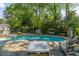 Backyard with a gunite pool, lush landscaping, lounge chairs and lots of mature trees at 5641 Roberts Dr, Dunwoody, GA 30338