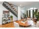 Open concept living area with hardwood floors, exposed staircase and a large arched window at 1253 Caroline Ne St # 229, Atlanta, GA 30307