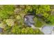 Aerial shot of estate with lush surrounding trees, patio, hot tub, and meticulously landscaped grounds at 1410 Daley Ridge Ct, Lawrenceville, GA 30045