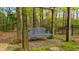 Cozy backyard swing bench with arbor surrounded by trees and foliage; perfect for relaxing outdoors at 1410 Daley Ridge Ct, Lawrenceville, GA 30045
