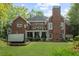 Rear view of brick home with covered patio, deck, and hot tub at 1410 Daley Ridge Ct, Lawrenceville, GA 30045