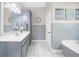 Bathroom with a double sink vanity, white-paneled wall, and tub at 1410 Daley Ridge Ct, Lawrenceville, GA 30045