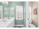Fresh bathroom featuring ample natural light, a white vanity with plenty of storage, and a refreshing mint-green color scheme at 1410 Daley Ridge Ct, Lawrenceville, GA 30045