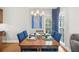 Elegant dining area featuring a chandelier, table set with blue accents, and natural light from large windows at 1410 Daley Ridge Ct, Lawrenceville, GA 30045